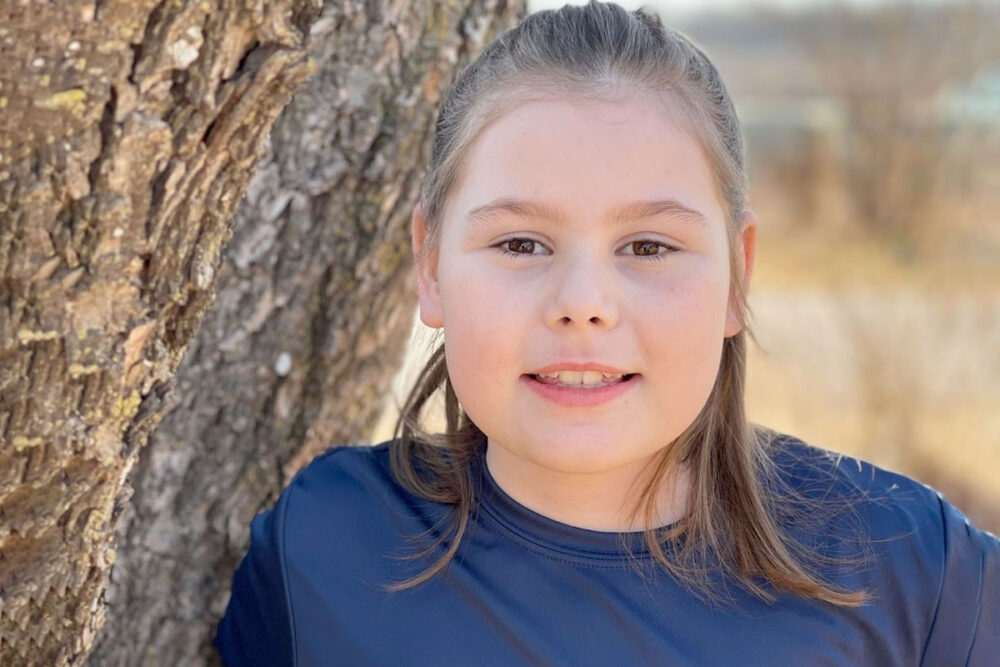 Girl leaning against tree